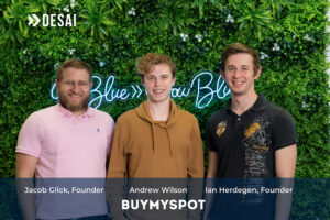 BuyMySpot founders in front of a wall of greenery