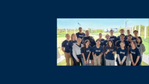 A group of people in navy t-shirts at a Top Golf range
